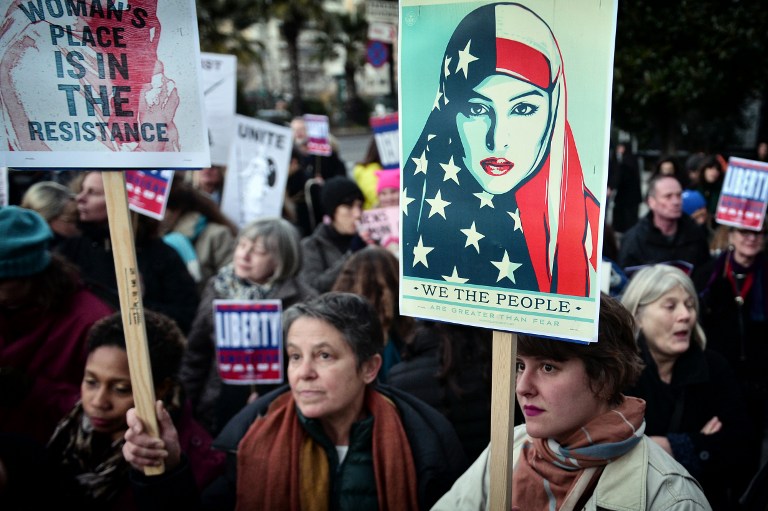 TO GO WITH AFP STORY BY JESSICA LOPEZ (FILES) This file photo taken on January 21, 2017 shows women holding placards during an demonstration in front of the US embassy in Athens, in solidarity with the Women's March on Washington, one day after the inauguration of Donald Trump as US President. The 40th International Women's Day will be marked on March 8, 2017. / AFP PHOTO / LOUISA GOULIAMAKI