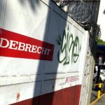 A man walks past the corporate logo of Odebrecht in a construction site in Caracas