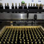 Red wine bottles are inspected by a worker at the Clos Apalta vineyards at Colchagua valley, south of Santiago