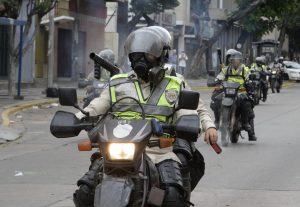 Riot police ride their motorbikes during a march against President Nicolas Maduro, in Caracas on May 1, 2017. Security forces in riot vans blocked off central Caracas Monday as Venezuela braced for pro- and anti-government May Day protests one month after a wave of deadly political unrest erupted. / AFP PHOTO / FEDERICO PARRA