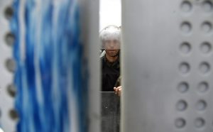 A Bolivarian National Guard member stands behind a fence as Venezuelan opposition activists take part in a women's march aimed to keep pressure on President Nicolas Maduro, whose authority is being increasingly challenged by protests and deadly unrest, in Caracas on May 6, 2017. The death toll since April, when the protests intensified after Maduro's administration and the courts stepped up efforts to undermine the opposition, is at least 36 according to prosecutors. / AFP PHOTO / JUAN BARRETO