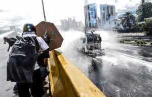 Opposition activists clash with the police as they block the Francisco Fajardo highway in Caracas during a demonstration against President Nicolas Maduro's government on May 29, 2017.  Demonstrations that got underway in late March have claimed the lives of 59 people, as opposition leaders seek to ramp up pressure on Venezuela's leftist president, whose already-low popularity has cratered amid ongoing shortages of food and medicines, among other economic woes. / AFP PHOTO / Juan BARRETO