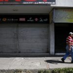 A man walks past closed stores near the border with Colombia, at San Antonio in Tachira state