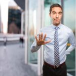 joven-empresario-serio-haciendo-gesto-mantener-calma_1459-1948