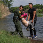 Asylum-seeking migrants cross the Rio Grande river in Del Rio