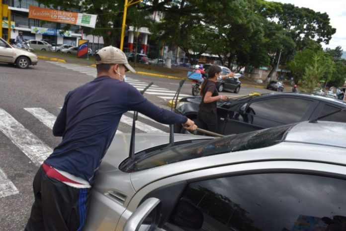 Jóvenes y adultos se ganan la vida limpiando vidrios en semáforos