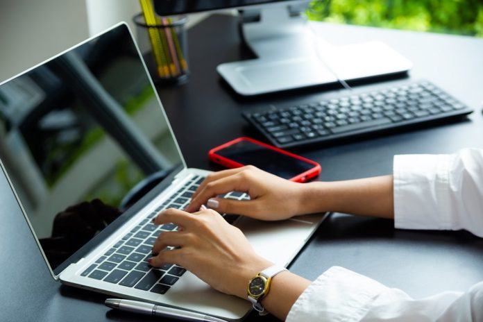 Female hand typing on keyboard of laptop intervención cambiaria